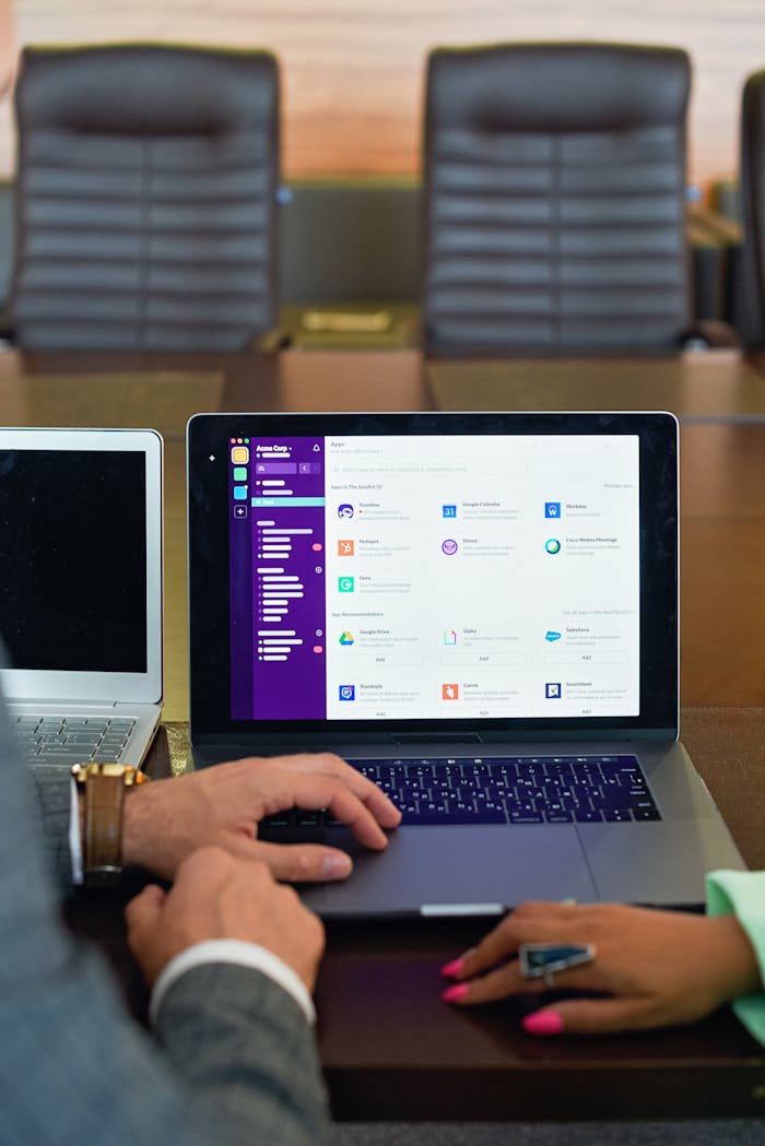 Business professionals collaborate using laptops in a modern office setting, enhancing productivity and teamwork.